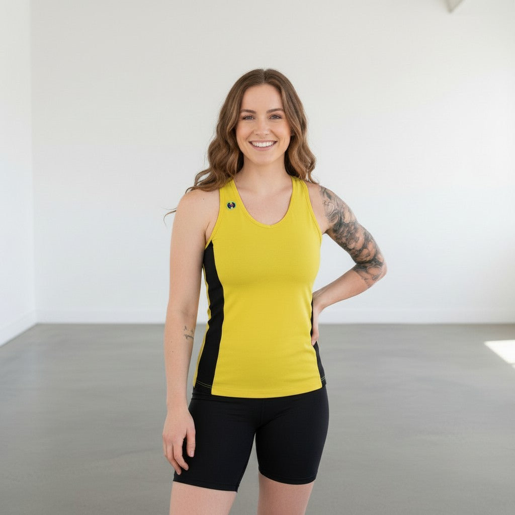 Pivotstar yellow athletic tank top with black side panels, racerback, and logo detail. Model wears black shorts.